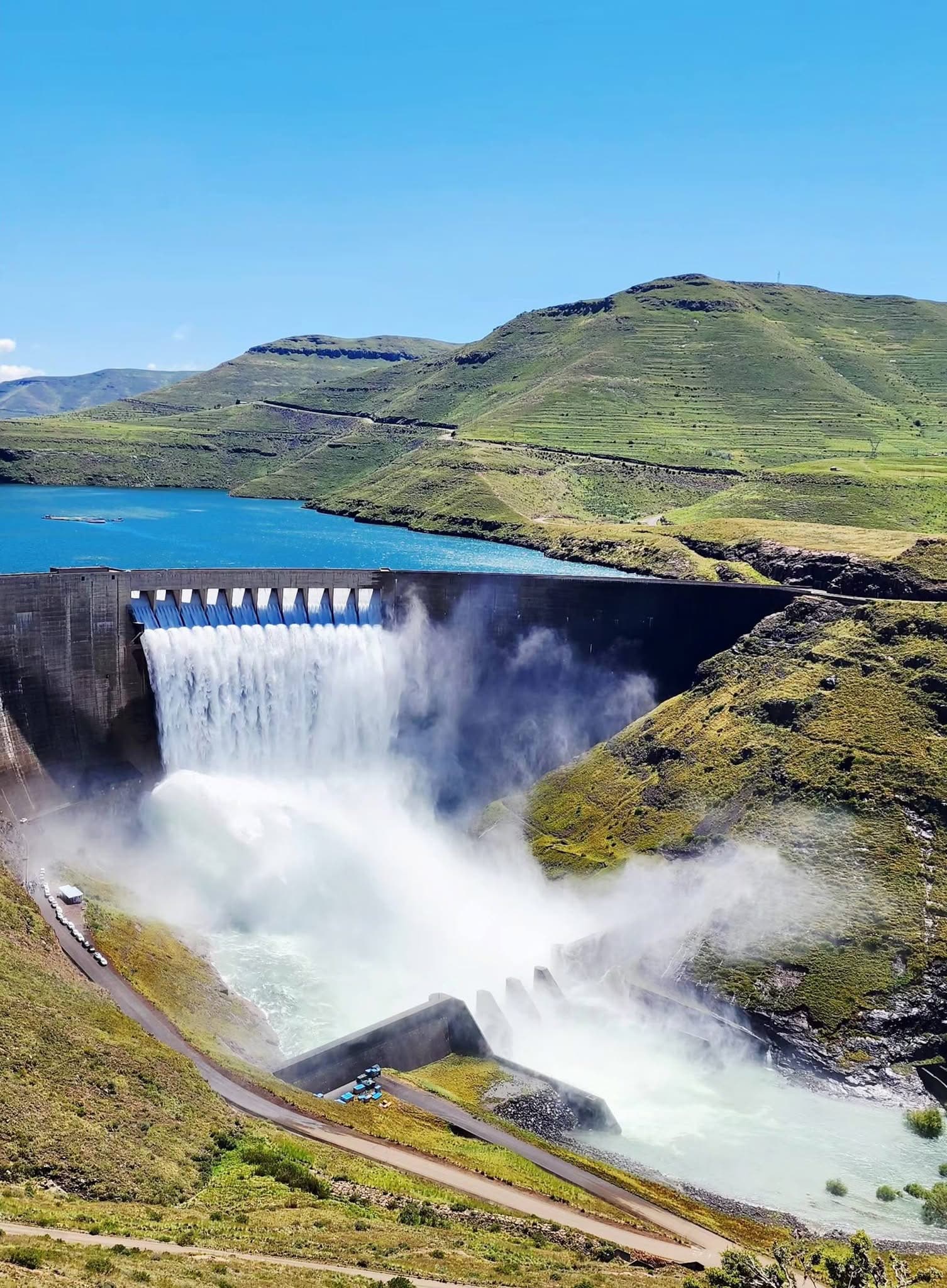 The curved concrete wall of Katse Dam rising above the valley