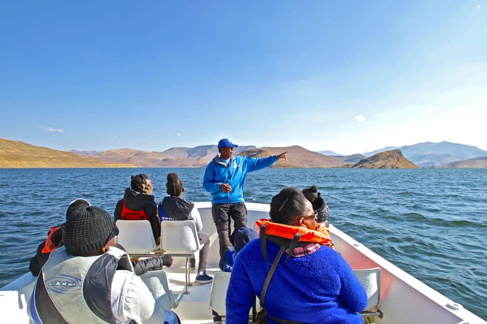 Boat gliding across still water on a Lesotho mountain dam